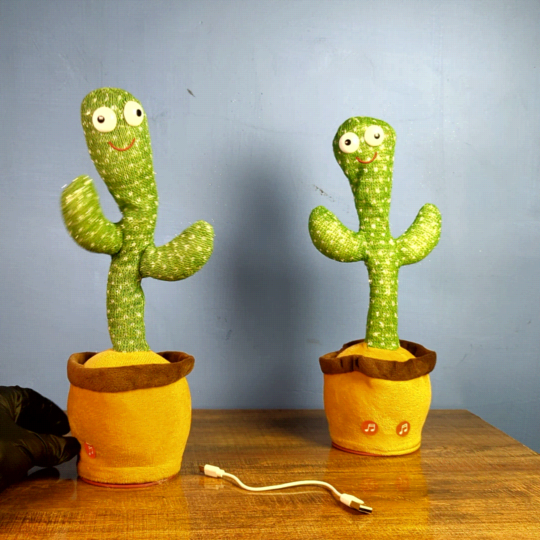 Cactus is Dancing & Talking with smiling cactus design, music icons on the pot and USB charging cable on a wooden table.